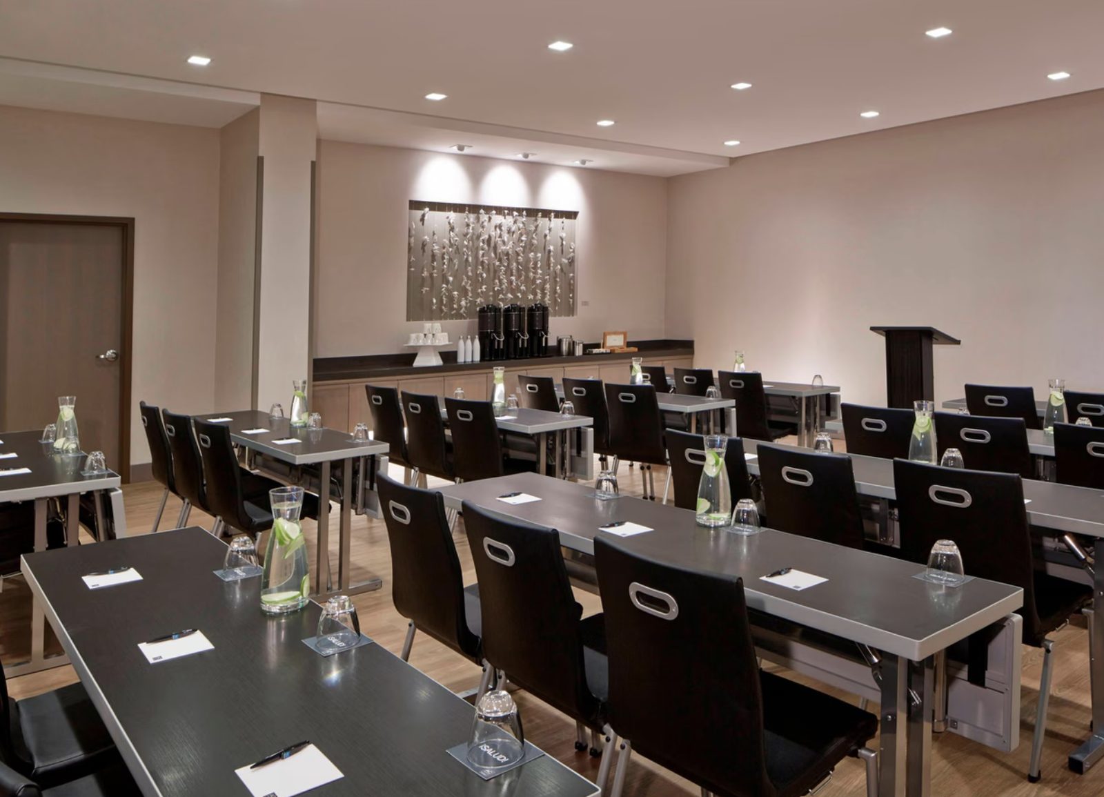 The main meeting room at the AC Hotel Bellevue, set with rows of tables and a lectern